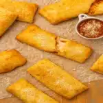 Hot Pocket Air Fryer – Crispy Perfection in 8 Minutes (Never Soggy!) 4 Golden brown Hot Pockets in an air fryer basket showing crispy exterior with melted cheese visible through a cut opening, demonstrating the perfect air fryer cooking method
